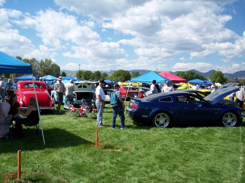 1972 Ford Ranchero - A blue coupe, possibly a Ford Mustang from the mid-2000s, is displayed with its hood open at an outdoor car show.