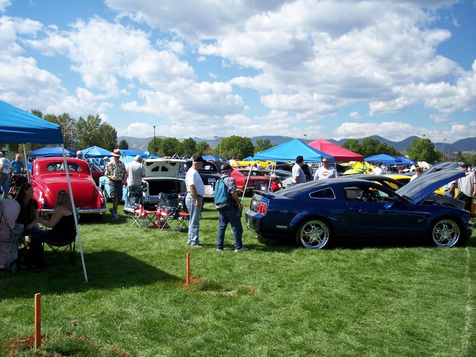 Blue coupe with hood open at a car show