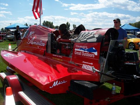 1972 Ford Ranchero - A bright red racing boat, named 'Miss America', is displayed on a trailer at an outdoor event.