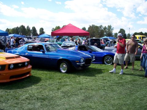 1972 Ford Ranchero - A blue coupe with a prominent hood scoop is on display at an outdoor car show.