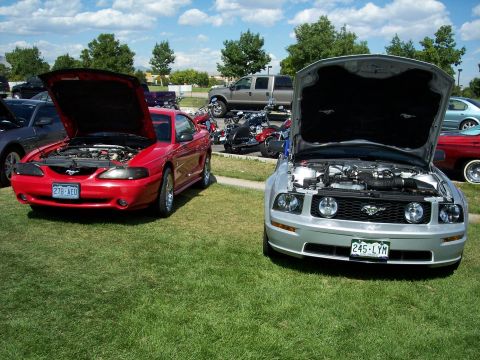 1972 Ford Ranchero - Two Ford Mustangs, a silver 2005 model and a red earlier generation, are displayed with their hoods open.