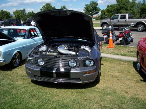 1972 Ford Ranchero - A gray Ford Mustang is parked on grass with its hood open, displaying the engine bay.
