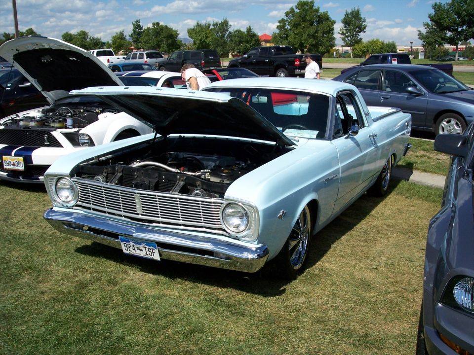 Light blue 1966 Ford Fairlane Ranchero with hood open, parked on grass next to other cars