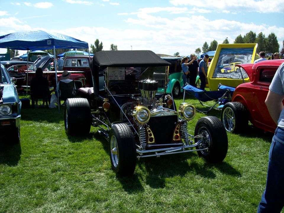 Black hot rod with exposed engine and gold accents, front view