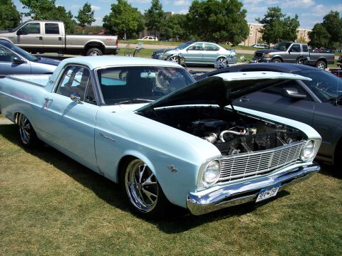 1972 Ford Ranchero - Light blue Ford Ranchero parked on grass with hood up, revealing the engine bay.