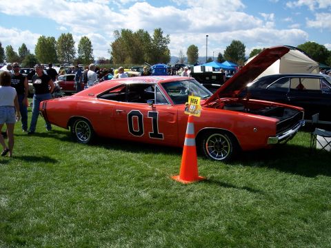 1972 Ford Ranchero - A classic orange Dodge Charger, famous for its "01" door decal, is displayed with its hood open at an outdoor car show.