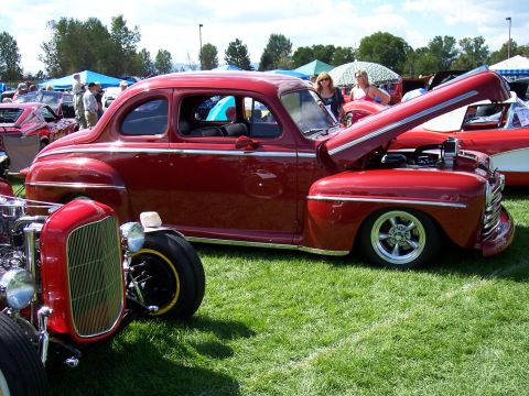 1972 Ford Ranchero - A classic red coupe is displayed with its hood open at an outdoor car show.