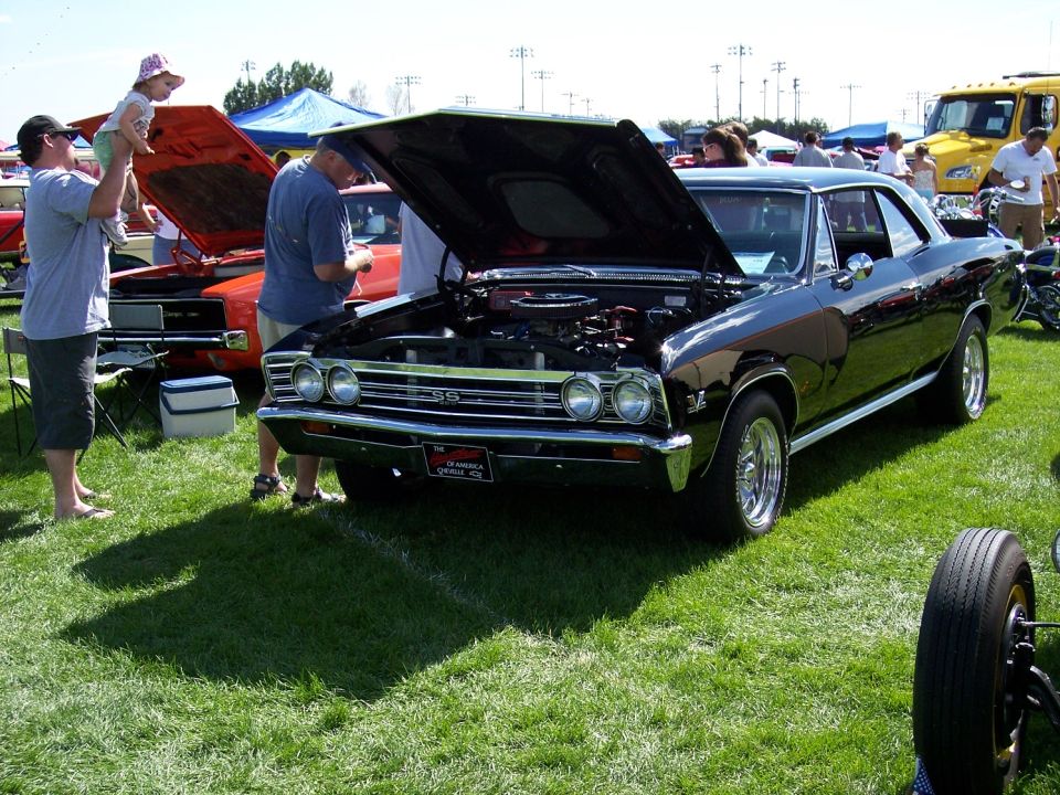 1966 Chevrolet Chevelle SS with hood open, parked on grass at car show