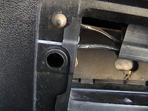 1977 Ford Mustang - Detail of a car's interior showing a plastic clip and exposed wiring behind a panel.