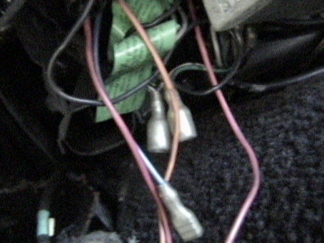 Close-up of a tangled mess of wires and connectors, some with green tape