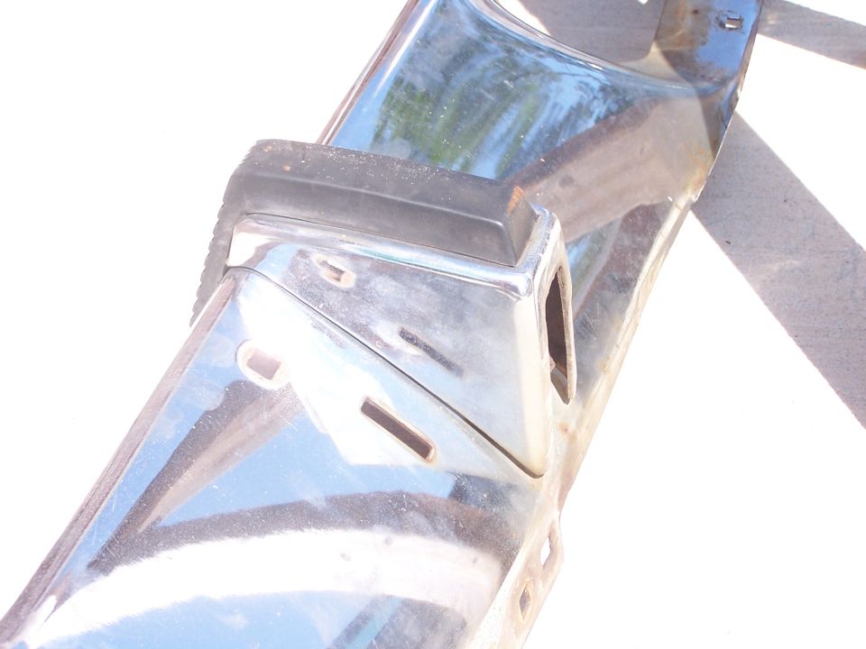 Chrome bumper section with black rubber trim and mounting holes