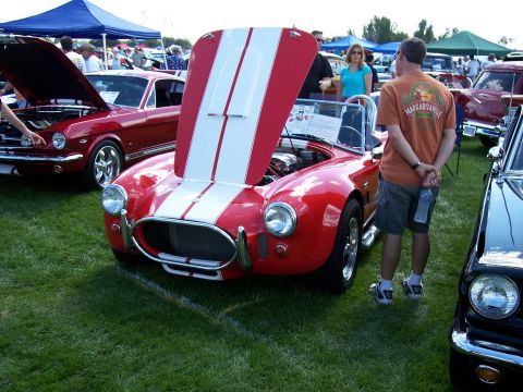 1972 Ford Ranchero - A red AC Cobra replica is displayed with its hood open at an outdoor car show.