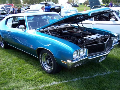 1972 Ford Ranchero - A blue 1970's era muscle car is displayed with its hood open at an outdoor car show.