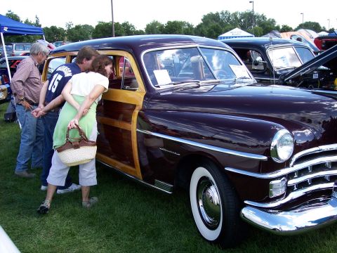 1972 Ford Ranchero - A group of people admire a classic woody wagon at an outdoor car show.