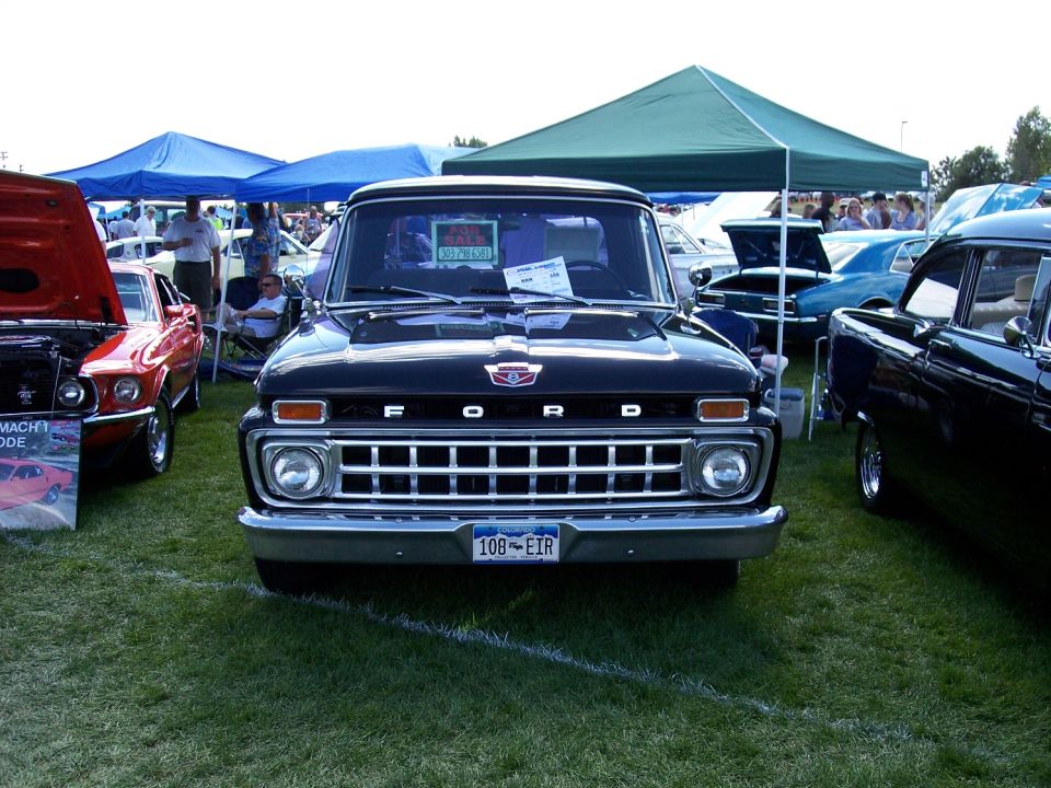 Black Ford pickup truck front view with chrome grille and license plate 108-EIR