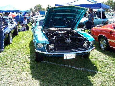 1972 Ford Ranchero - Front view of a teal 1969 Ford Mustang Mach 1 at an outdoor car show.