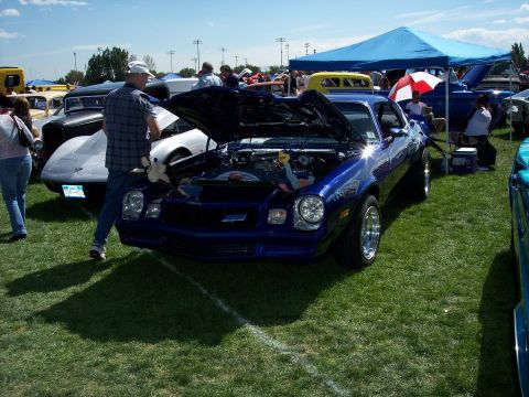 1972 Ford Ranchero - A blue Chevrolet Camaro is displayed with its hood open at an outdoor car show.