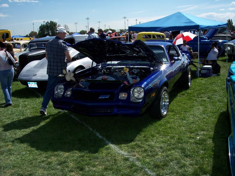 Blue 1978 Chevrolet Camaro with hood open at a car show. Another car is parked next to it