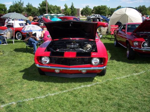 1972 Ford Ranchero - A red 1969 Chevrolet Camaro is displayed with its hood open at an outdoor car show.