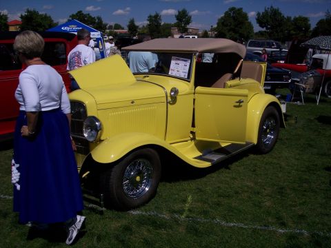 1972 Ford Ranchero - A yellow convertible hot rod is displayed with its hood and door open at an outdoor car show.