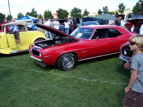 1972 Ford Ranchero - A red 1969 Chevrolet Camaro is displayed with its hood open at an outdoor car show.
