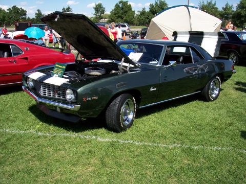 1972 Ford Ranchero - A dark green 1969 Chevrolet Camaro Z/28 is displayed with its hood open at an outdoor car show.