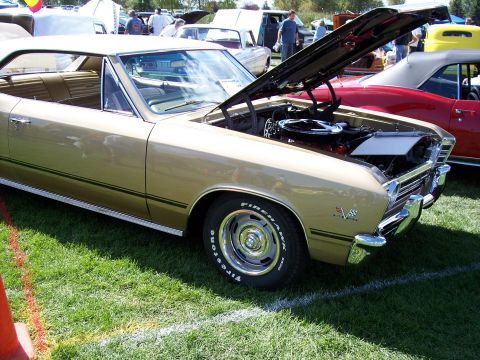 1972 Ford Ranchero - Gold 1967 Chevrolet Chevelle SS coupe on display with hood open at an outdoor car show.