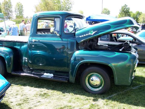 1972 Ford Ranchero - A classic green Ford F-100 pickup truck, likely from 1956, is displayed with its hood up, revealing the engine and custom flame graphics.