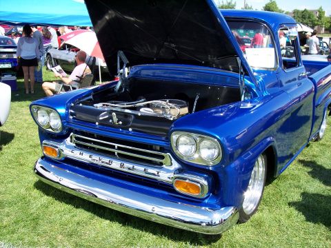 1972 Ford Ranchero - A shiny blue Chevrolet pickup truck is displayed with its hood open at an outdoor car show.