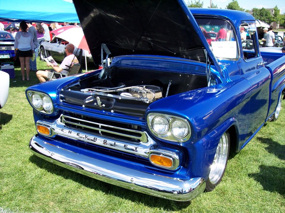 Blue Chevrolet pickup truck with hood open, showing engine. Chrome grille and bumper