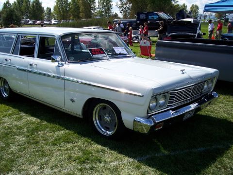 1972 Ford Ranchero - A white station wagon with a distinctive grille and chrome accents sits on a grassy field at an outdoor event.