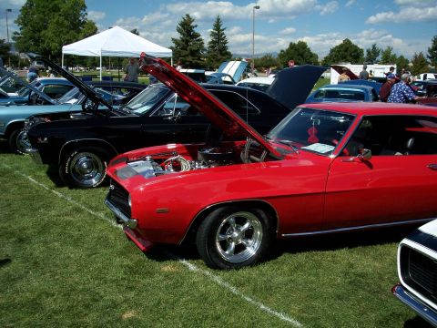 1972 Ford Ranchero - Several classic cars are displayed on a grassy field under a partly cloudy sky.