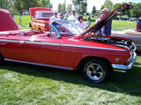 1972 Ford Ranchero - A classic red convertible is displayed at an outdoor car show with its hood open.