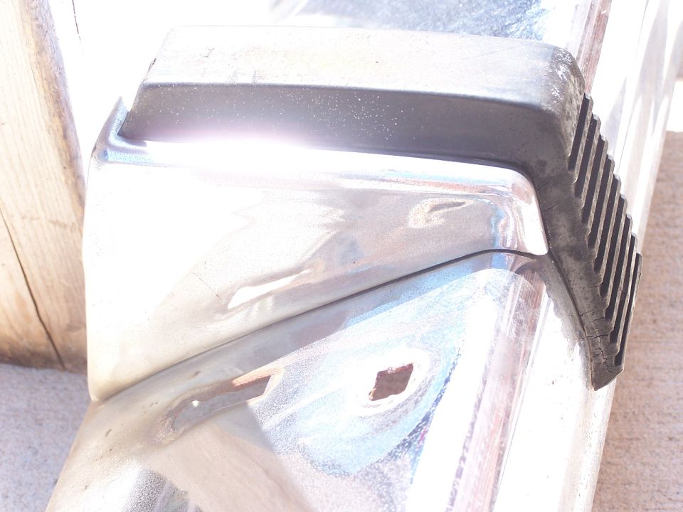Chrome bumper section with black rubber trim and visible mounting holes