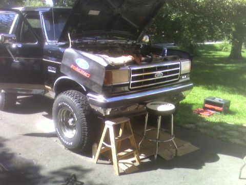 1990 Ford Bronco - This black 1990 Ford Bronco is shown with its hood open, suggesting maintenance or repair work is underway.