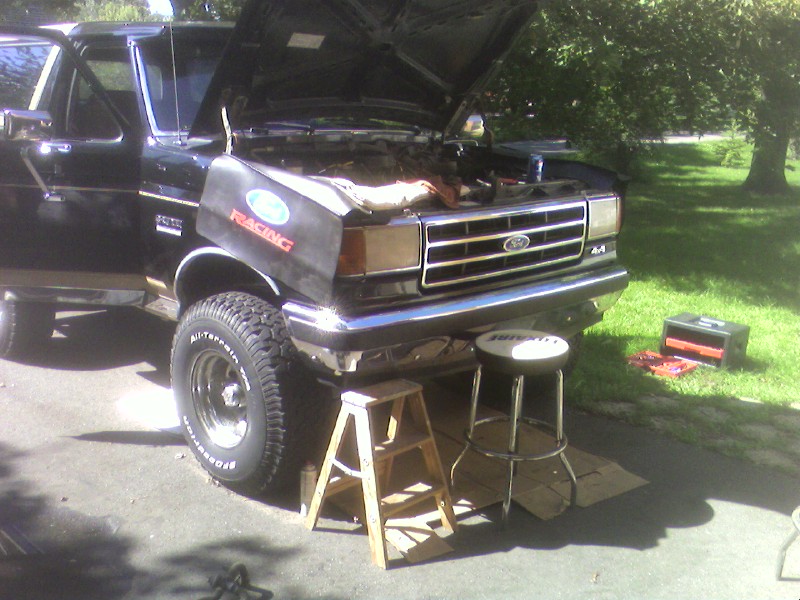 Black 1990 Ford Bronco with hood open, front view