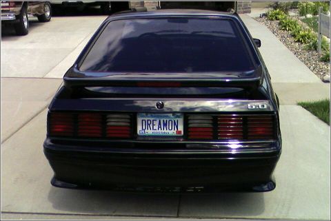 1989 Ford Mustang - Rear view of a black 1989 Ford Mustang GT, showing its distinctive taillights and '5.0' badging.