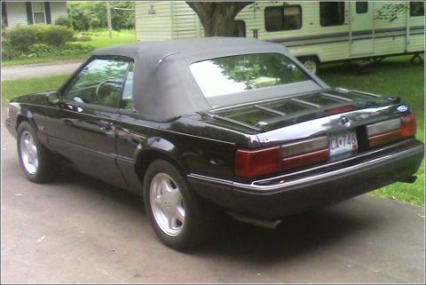 1989 Ford Mustang - This black 1989 Ford Mustang convertible is seen from the rear, showing its classic lines and a California license plate.
