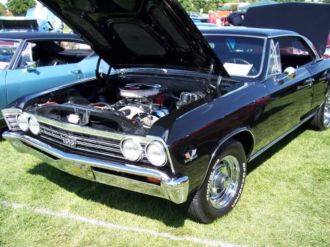 1972 Ford Ranchero - A black 1967 Chevrolet Chevelle SS is displayed with its hood open, revealing the engine, while another vehicle sits nearby.