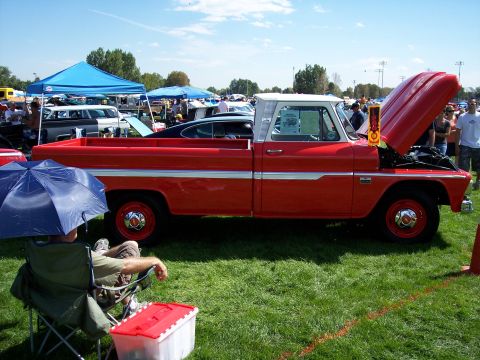 1972 Ford Ranchero - A red 1964 Chevrolet C10 pickup truck is displayed with its hood open at a car show.