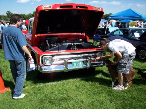 1972 Ford Ranchero - A red 1967 Ford pickup truck is displayed with its hood open at an outdoor car show.