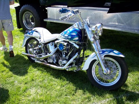 1972 Ford Ranchero - A custom motorcycle with blue flame paint is displayed on a grassy field.