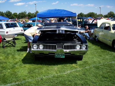 1972 Ford Ranchero - Front view of a black 1970 Oldsmobile Cutlass Supreme with its hood open at an outdoor car show.