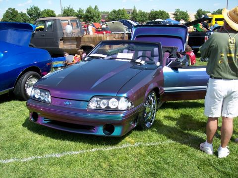 1972 Ford Ranchero - This customized Ford Mustang convertible features a unique iridescent paint job and is on display at an outdoor car show.
