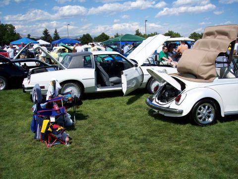 1972 Ford Ranchero - Multiple vehicles displayed with hoods and trunks open at an outdoor car show.
