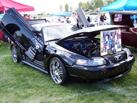 1972 Ford Ranchero - A modified black Ford Mustang is displayed with its doors and hood open, its engine and a photo collage.