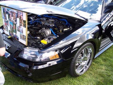 1972 Ford Ranchero - Black Ford Mustang with hood open, displaying engine and a photo collage on the hood.