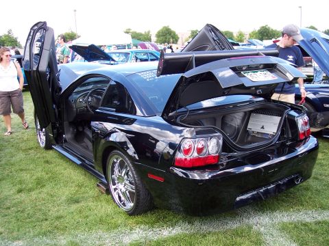 1972 Ford Ranchero - A black Ford Mustang with its doors and trunk open, displaying custom modifications and audio equipment.