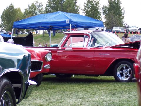 1972 Ford Ranchero - A red El Camino pickup is parked on a grassy field under a blue tent, with another vehicle in the foreground.