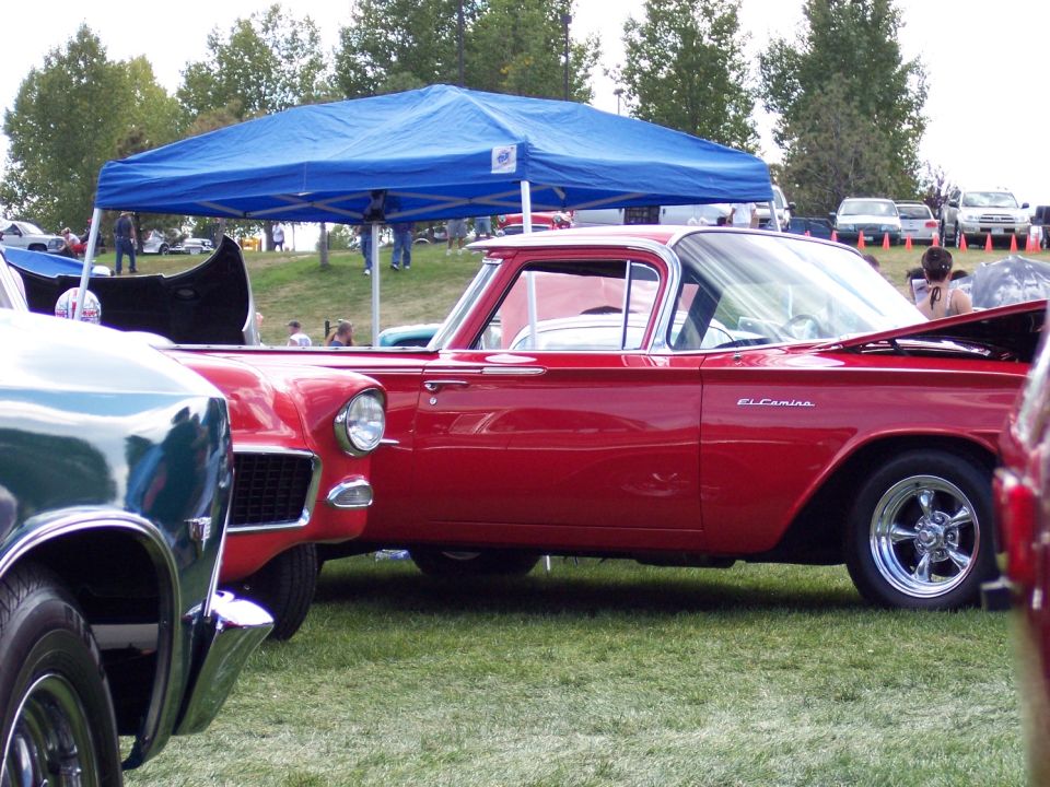 Red classic car with El Camino script and mag wheels at a show